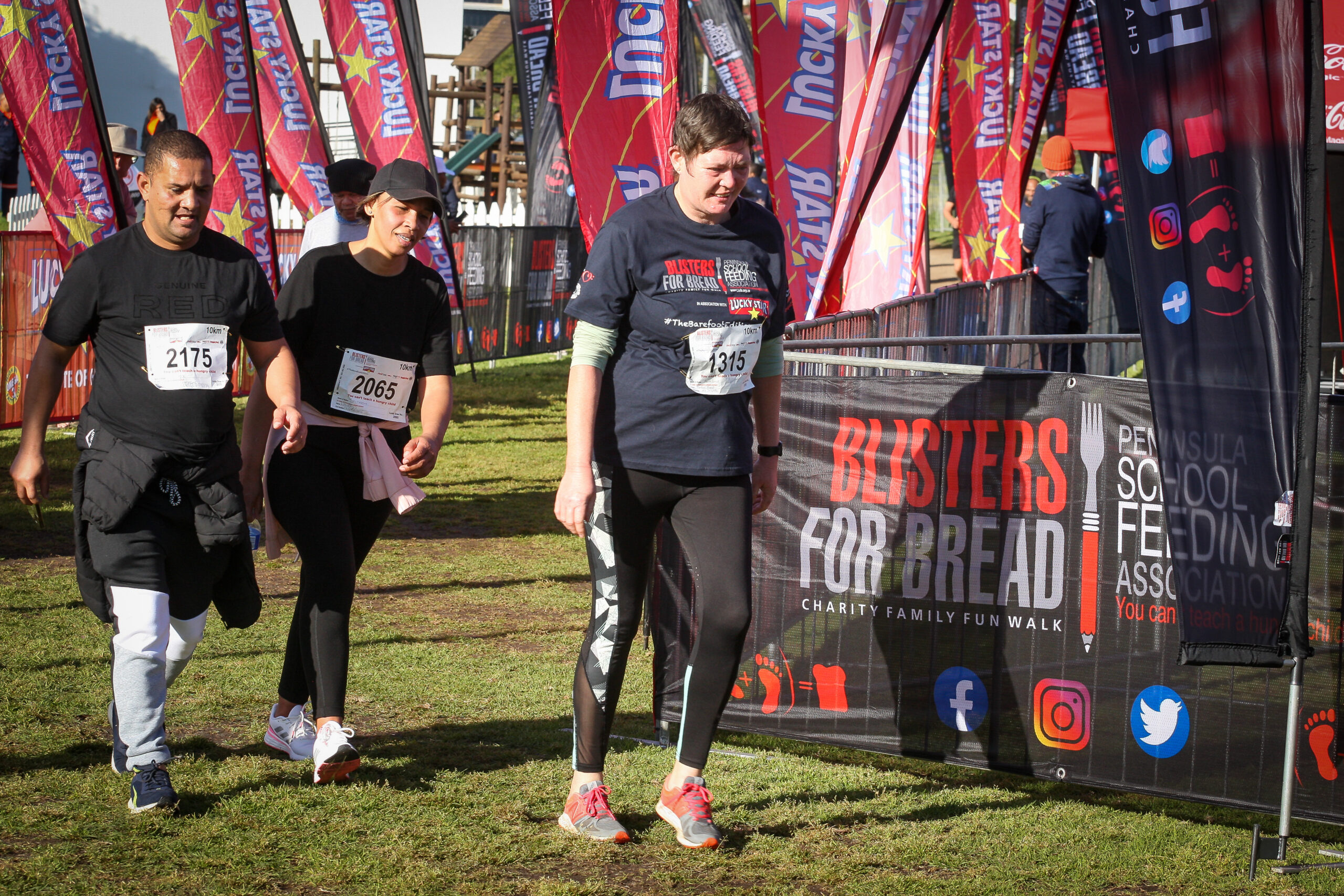 women walking on grass towards the finish line