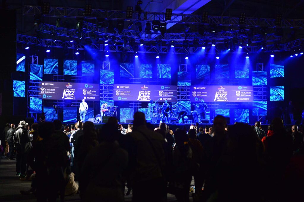 Spectators watching a Cape Town International Jazz Festival Performance on a blue lit stage