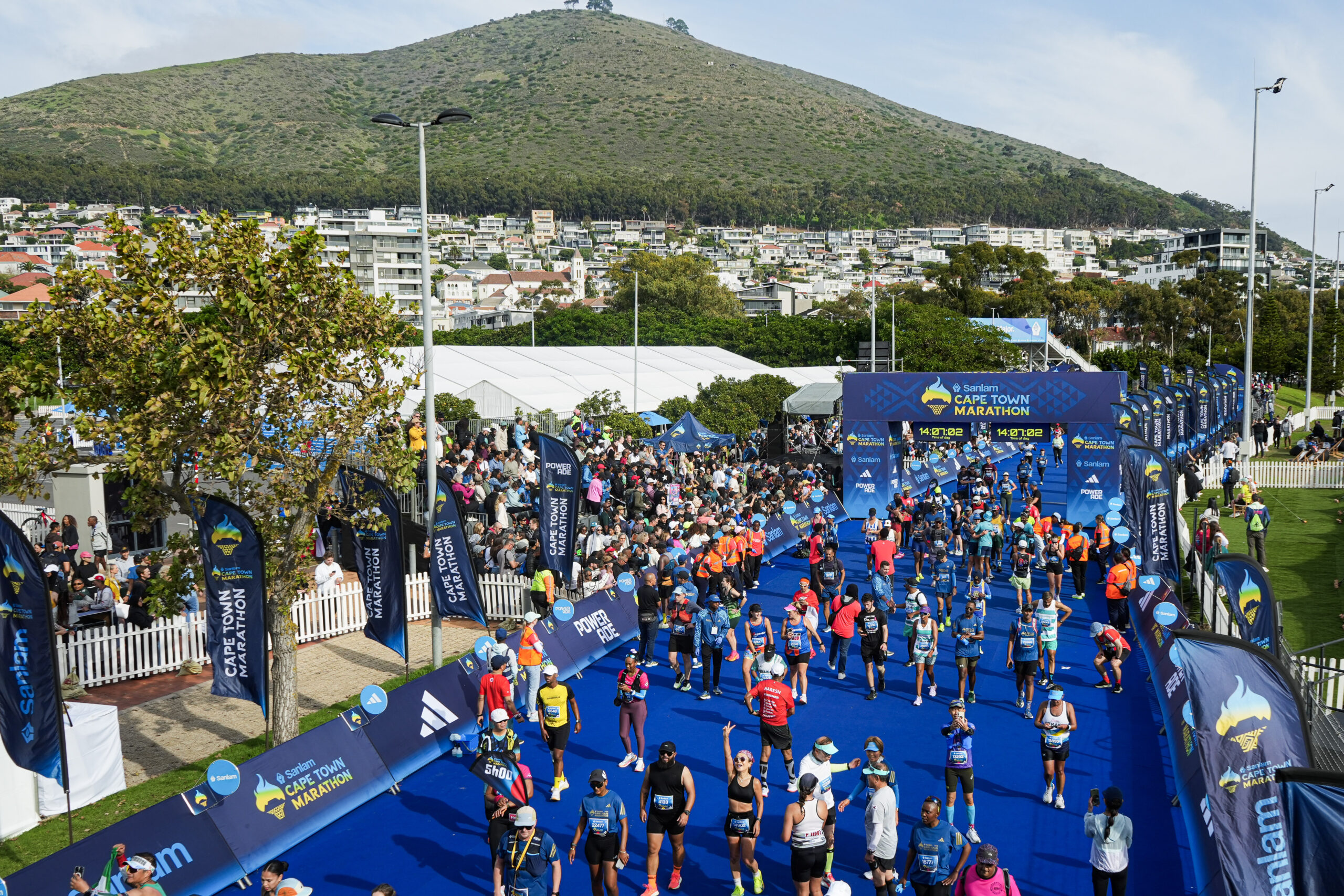 Cape Town Marathon runners at the race finish line in Green Point with Signal Hill as a backdrop